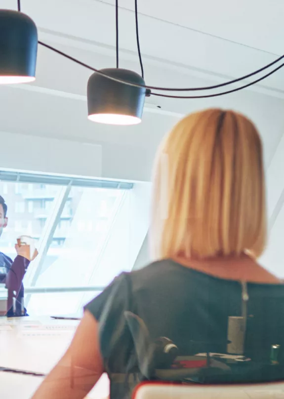 Office workers in a meeting room with presentation on screen