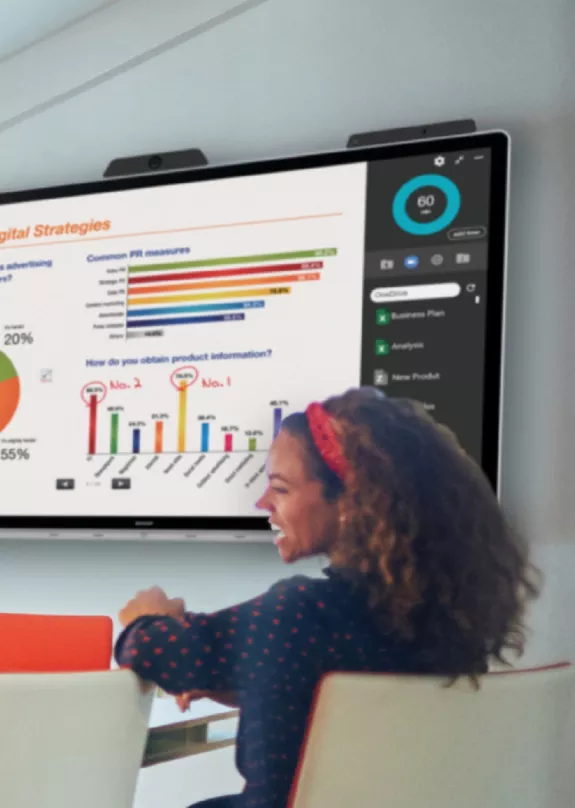 Office workers in a meeting room with presentation on screen